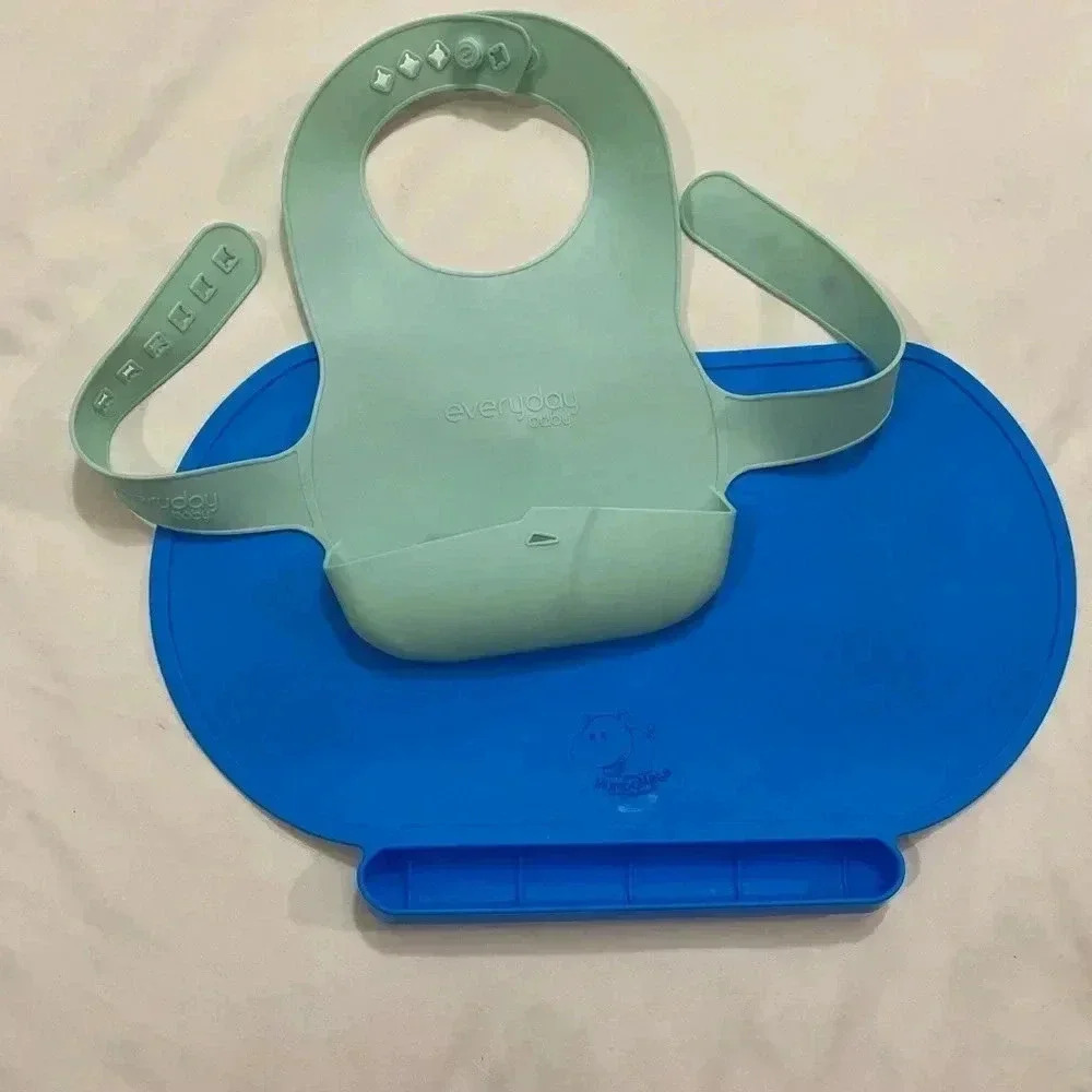 Baby green  silicone bib and blue Mambomats placemat.